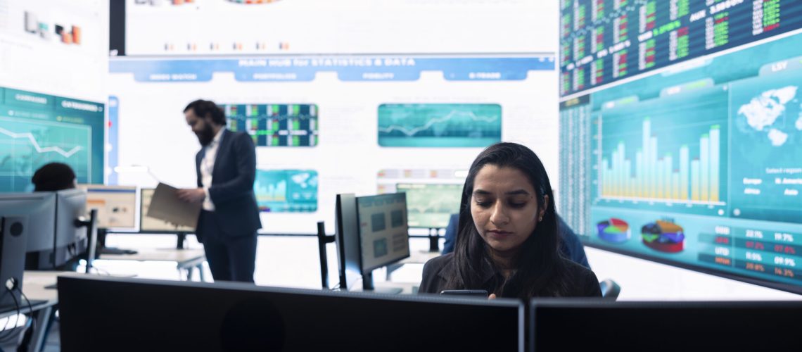 General manager working on data management with infographics and business activity reports, ensuring objective achievement. Shareholder reviewing an investment for global expansion.